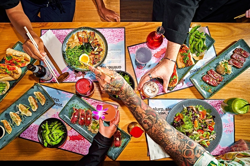 a photo showing hands reaching for food from restaurant dishes