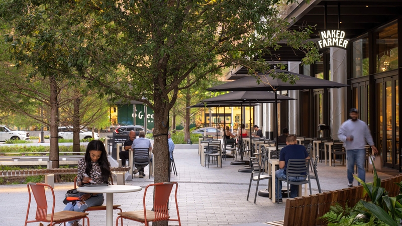 outdoor patios with diners beside an urban park