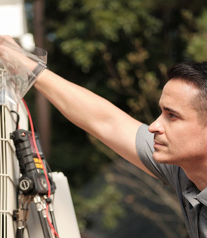 Uniformed Rycor tech installing a mini-split heat pump outside