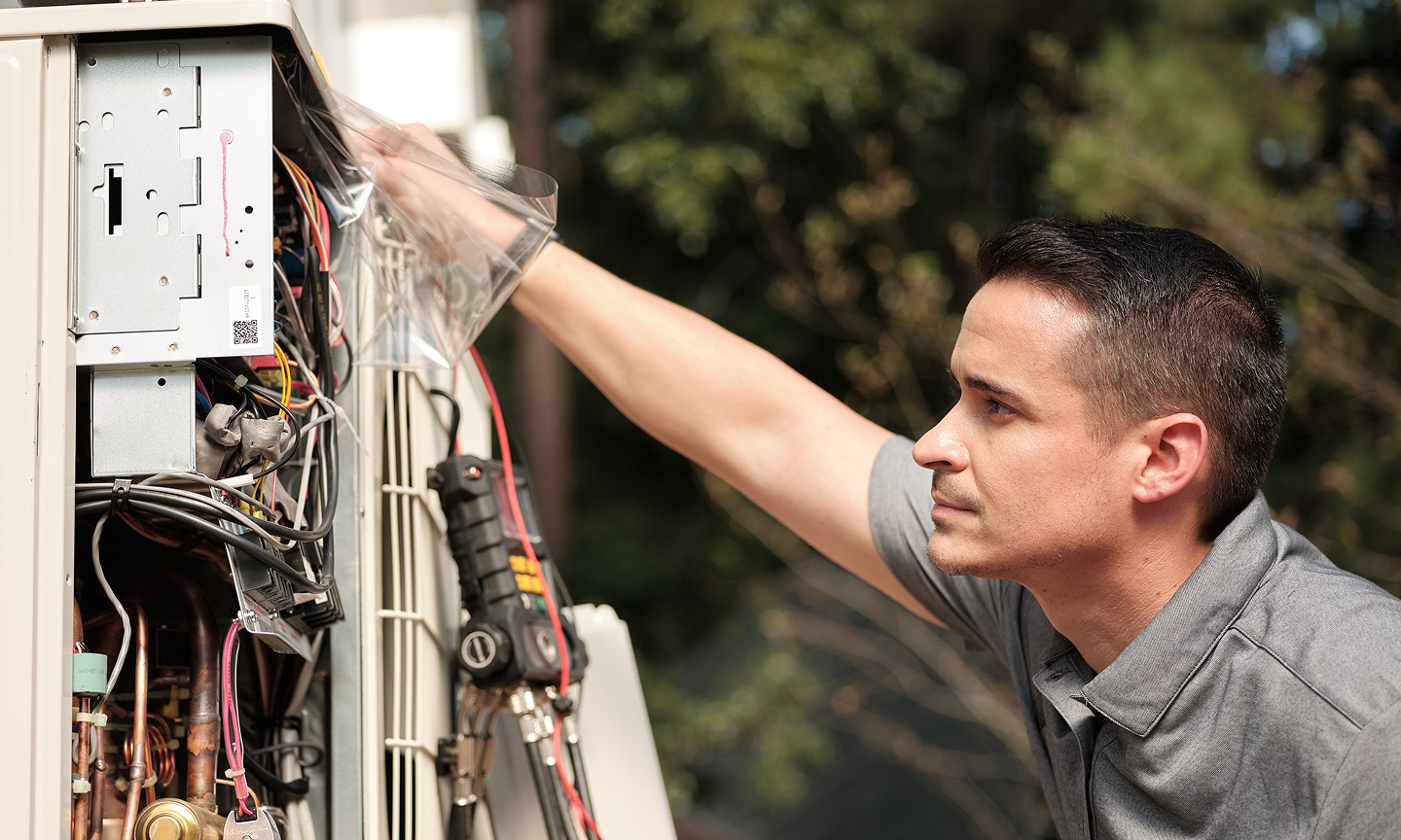 Uniformed Rycor tech installing a mini-split heat pump outside