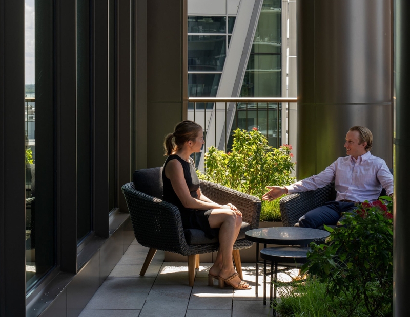 two coworkers talking on an outdoor patio