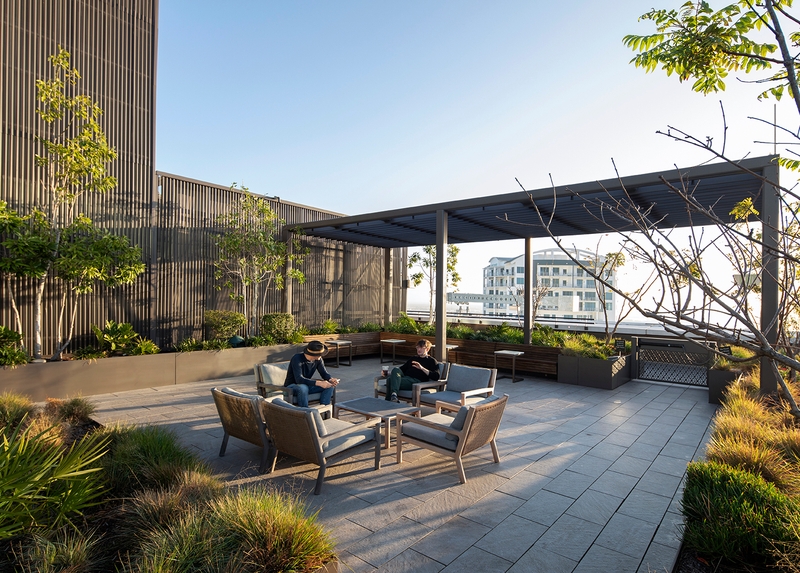 two men sitting on a rooftop patio