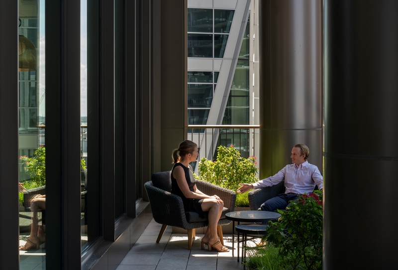 two coworkers talking on an outdoor patio