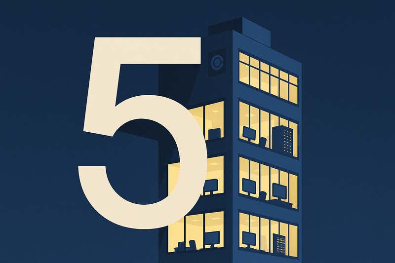 The number 5 over a building with the lights on and computers inside