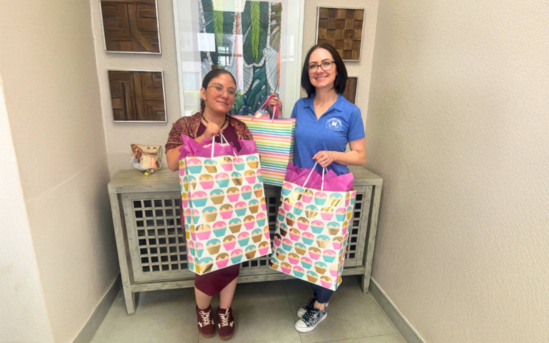 Two women holding large gift bags