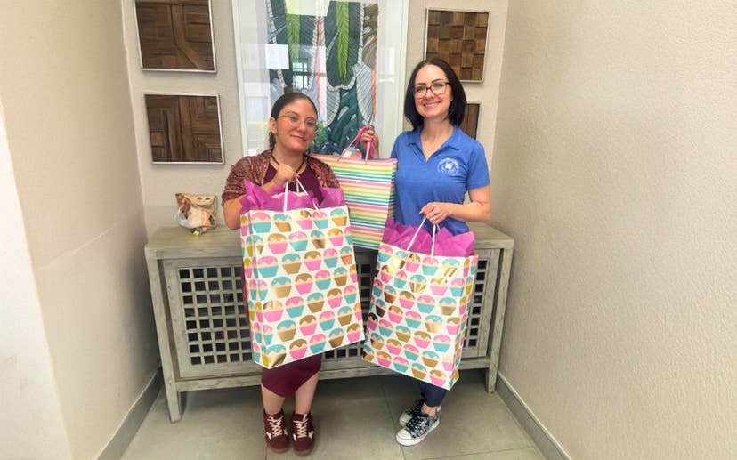 Two women holding large gift bags
