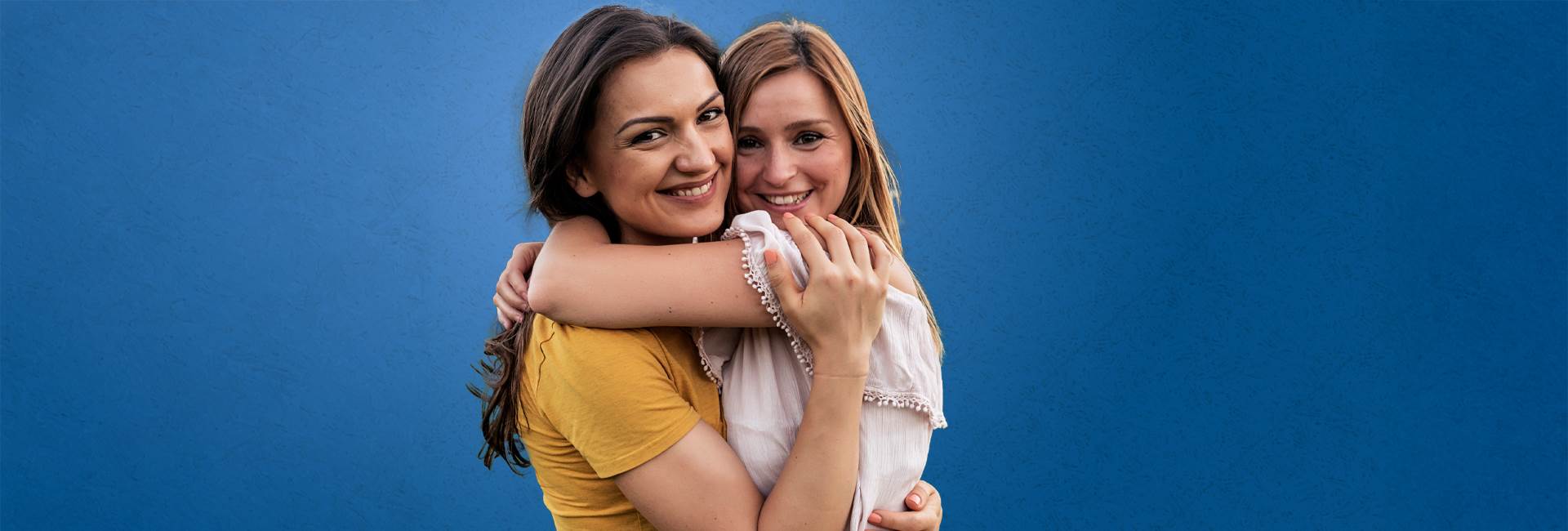 Mom and daughter hugging and smiling