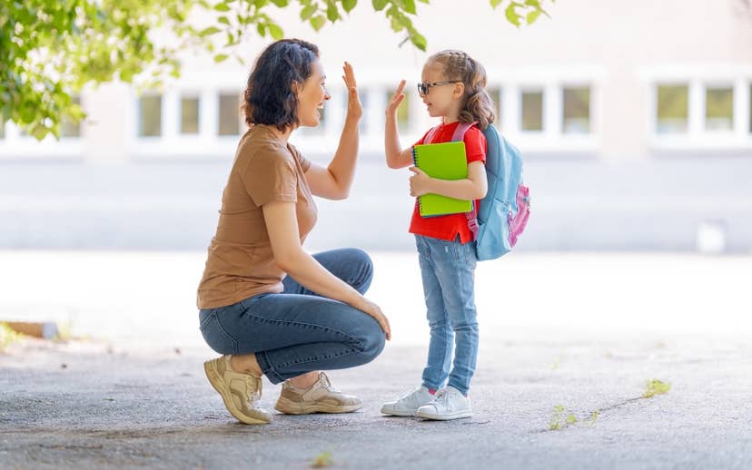 Mom bending down to give daughter a high five