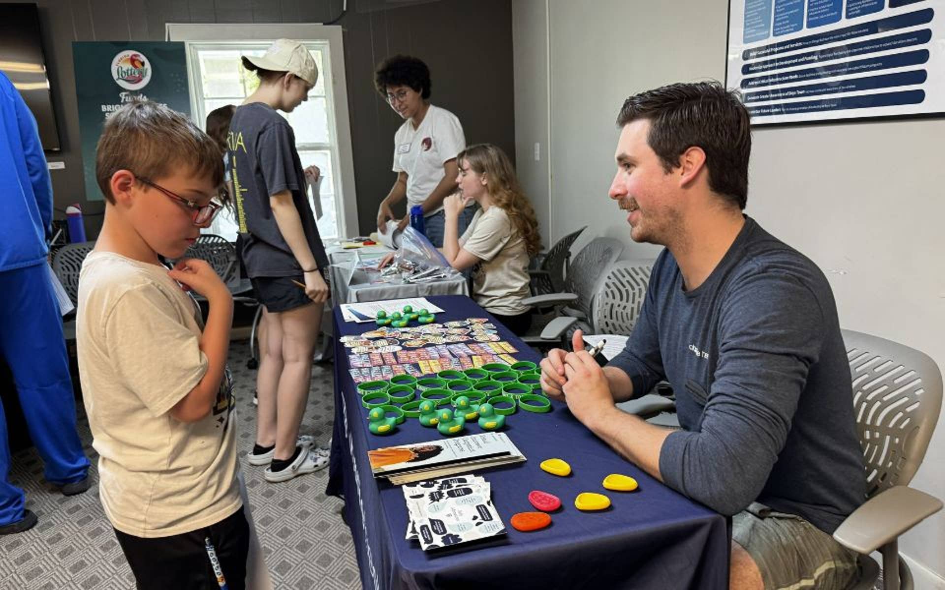Young Boy speaking with adult at career fair table