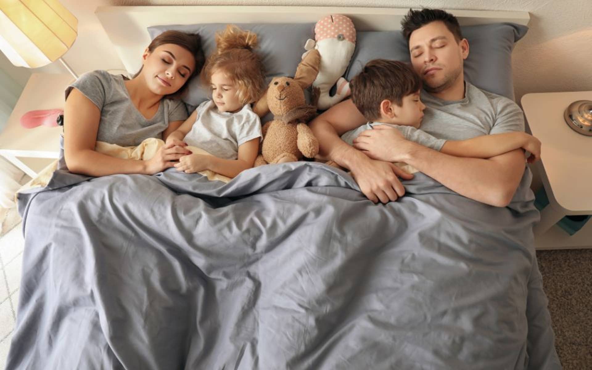 Mom and Dad in Bed with Sleeping Young Children