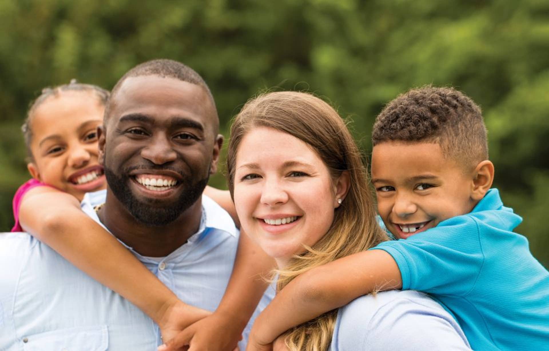 Dad, Mom and a child on each of their backs