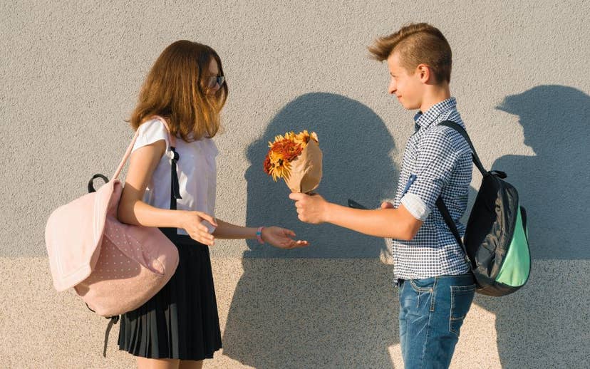 Teen boy giving teen girl flowers