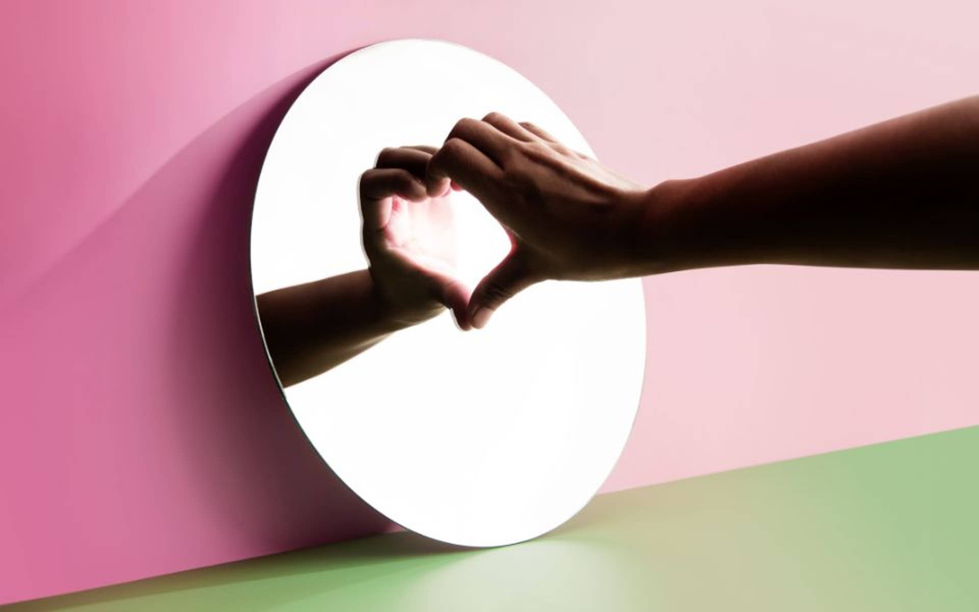 hand making a heart in a mirror