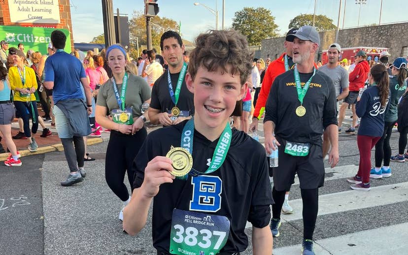Young Boy holding medal at Race finish line