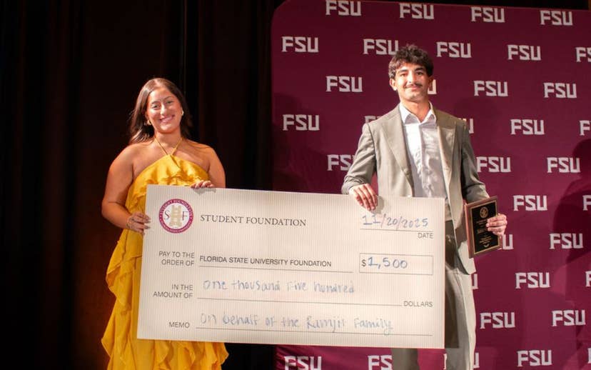 Student volunteer accepts award and donation check