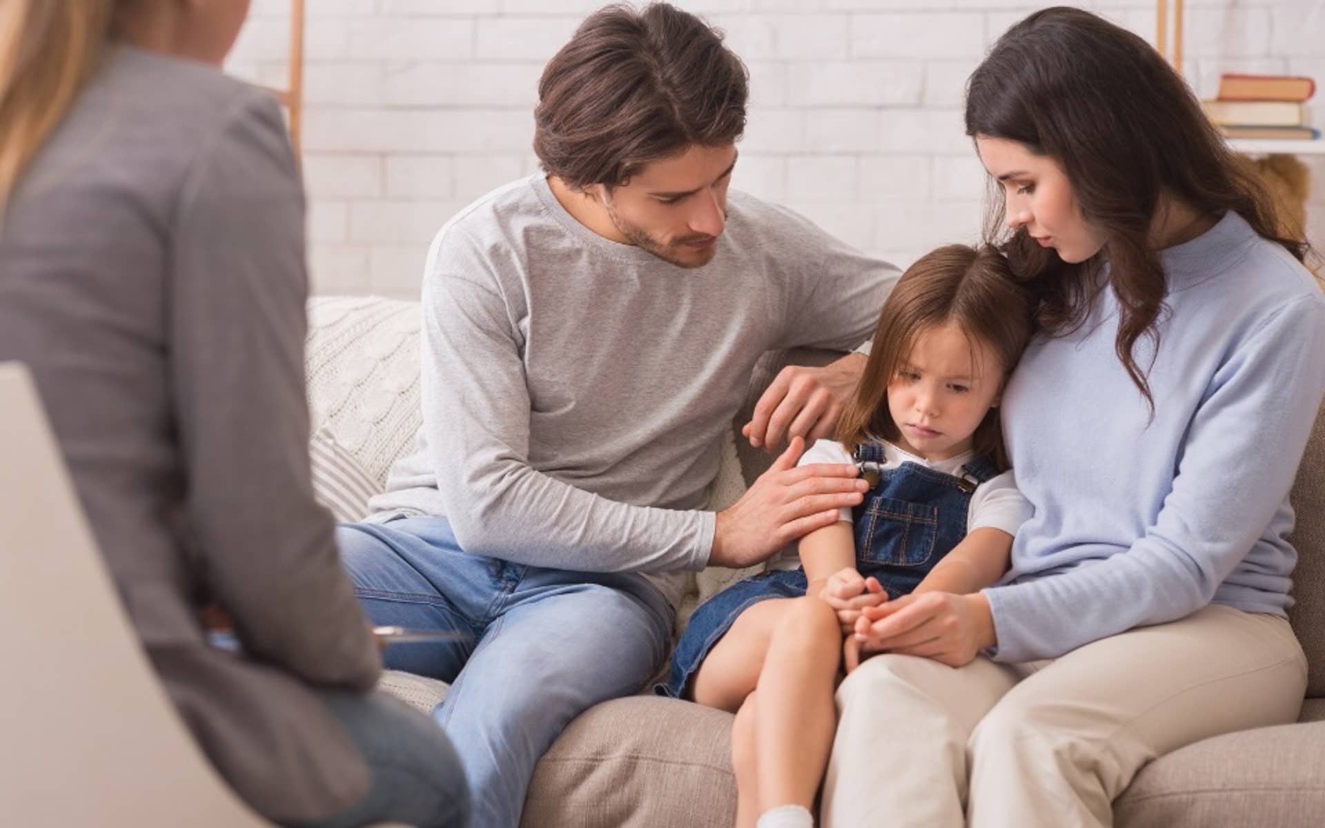 Dad and Mom on Couch consoling sad child