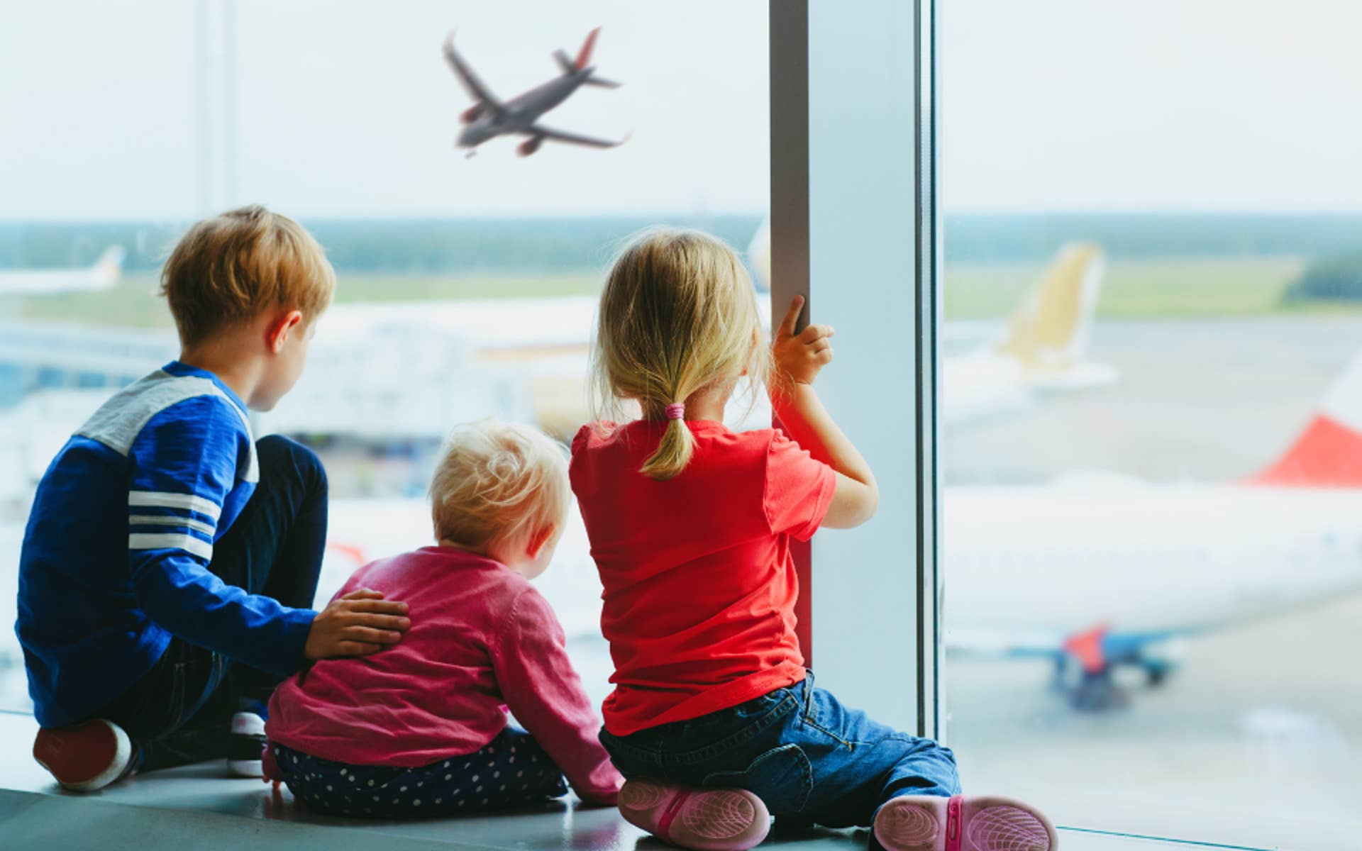Young Children looking through window at the Airport