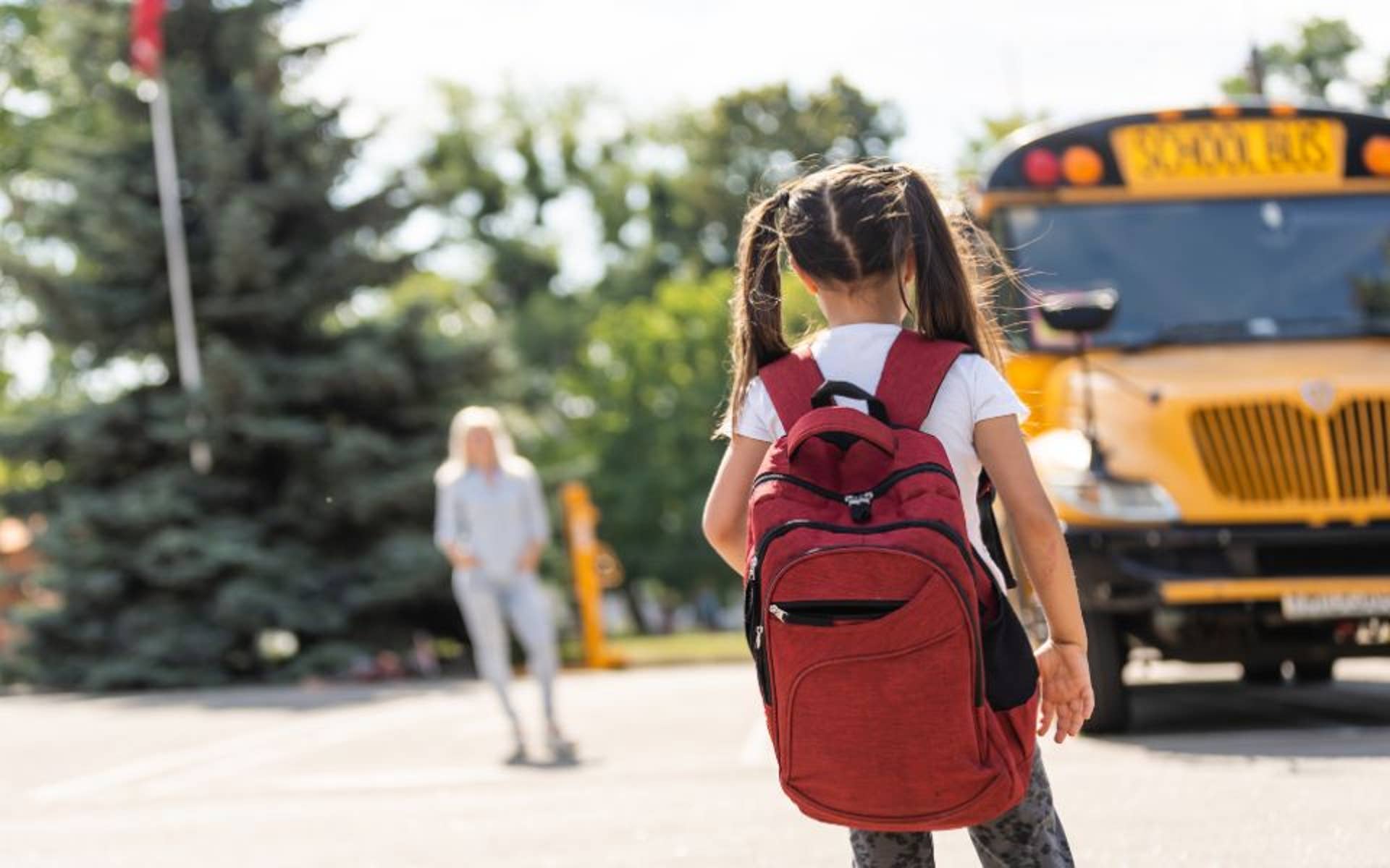 girl wearing large backpack getting on the bus