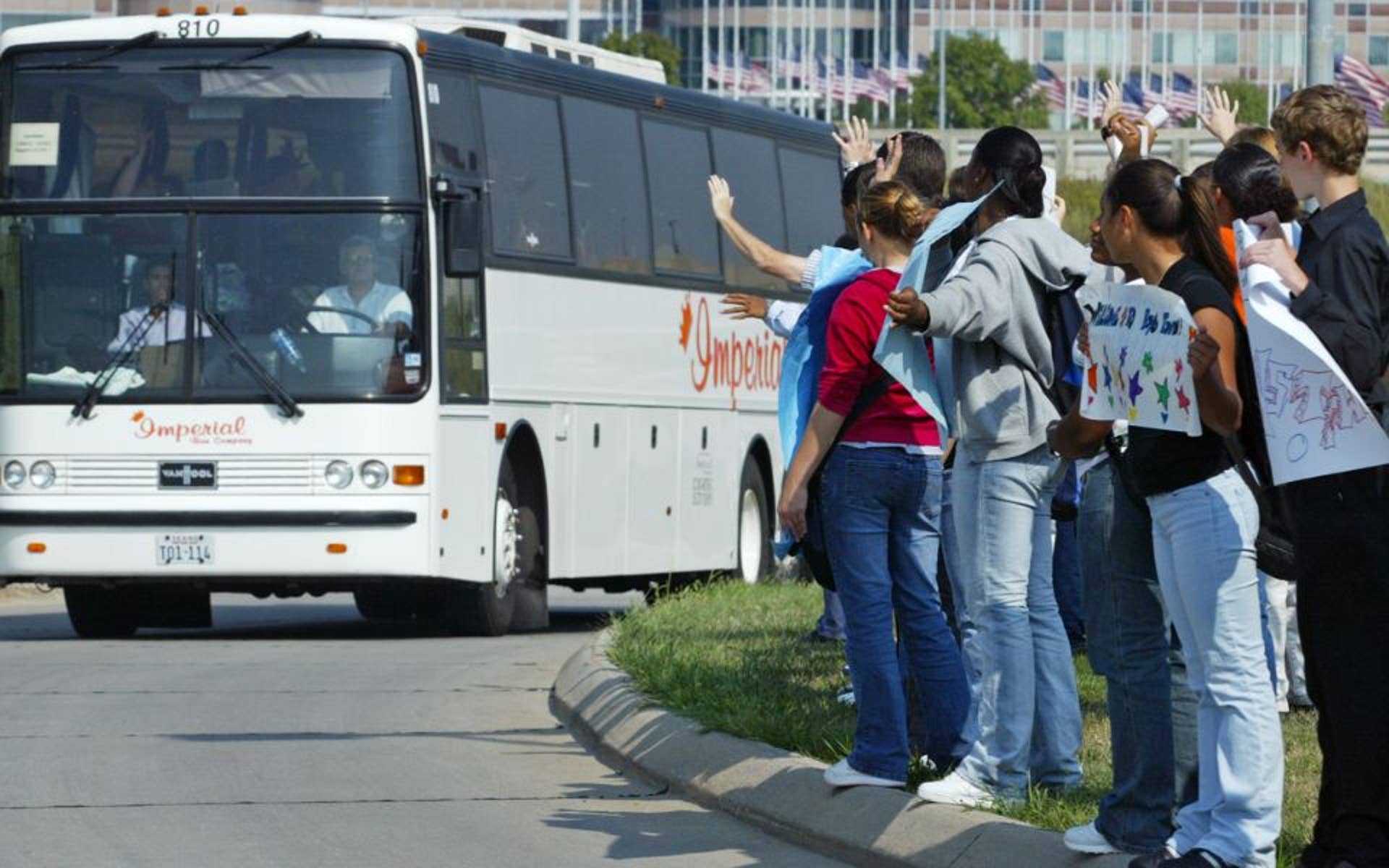 kids waving to a bus driving by 
