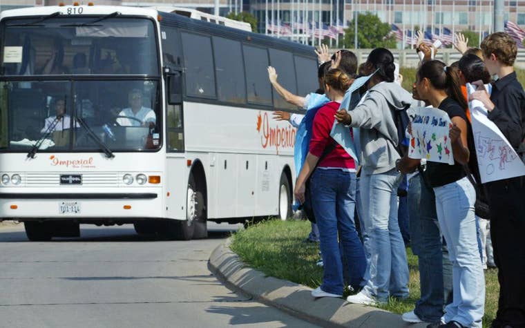 kids waving to a bus driving by