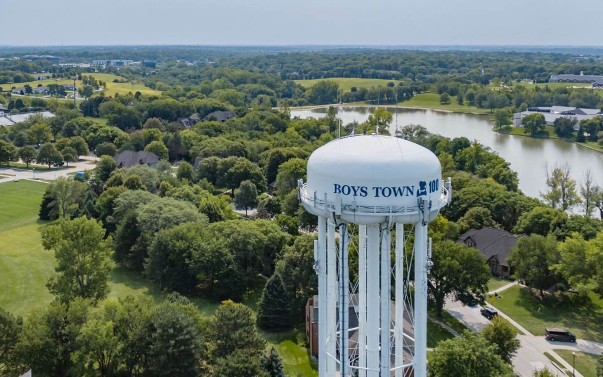 Overlook of Boys Town Campus with green trees and a white water tower