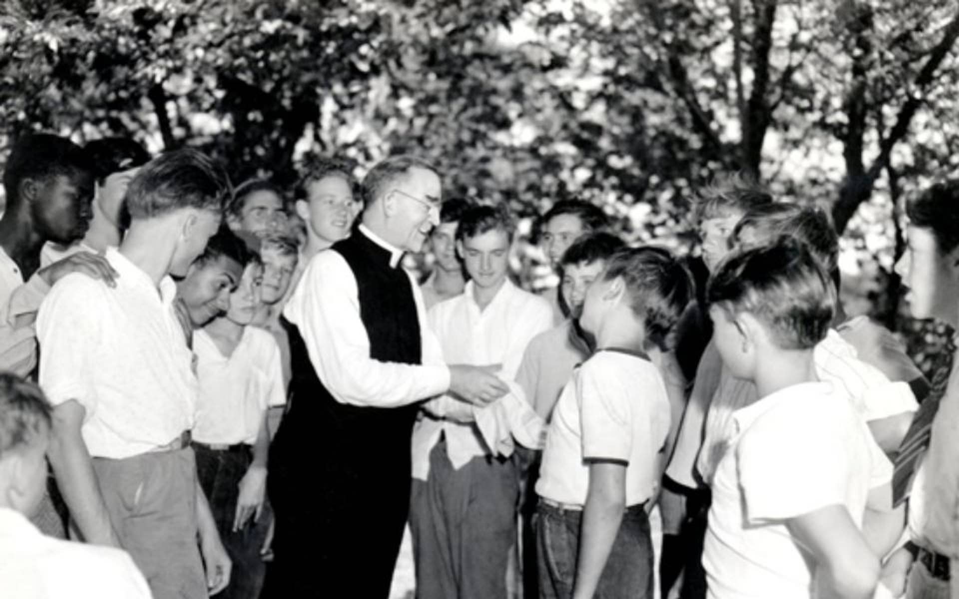Falther Flanagan talking with a group of boys 