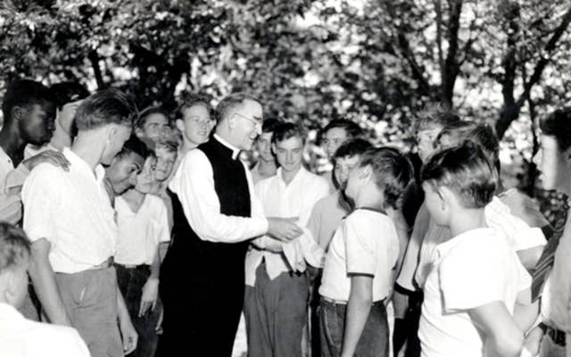 Father Flanagan talking with a group of boys 
