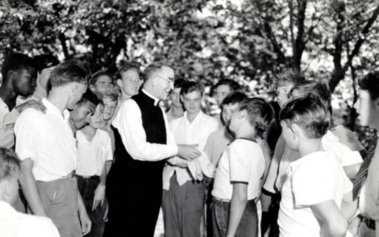 Falther Flanagan talking with a group of boys 