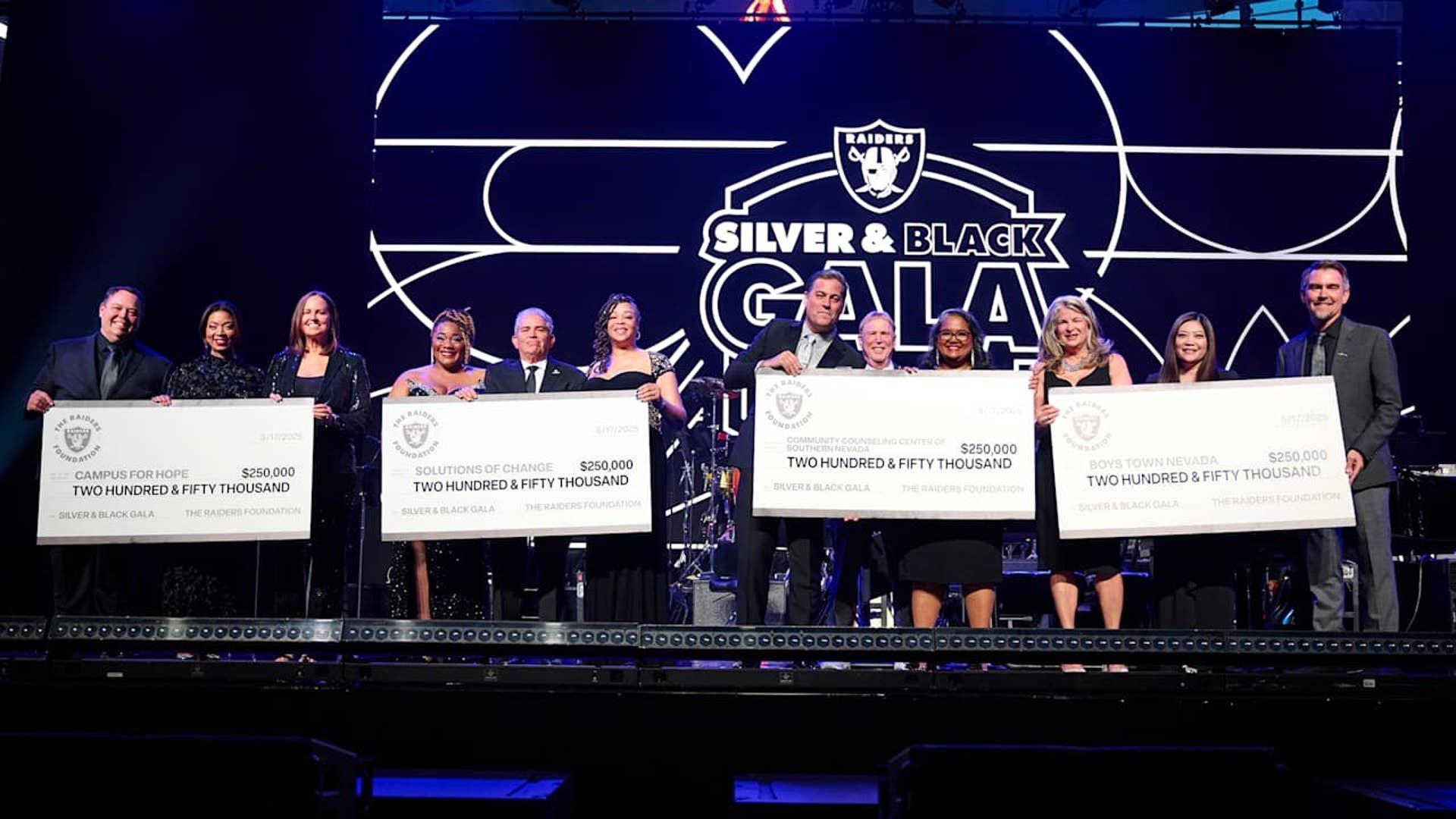 Men and Women dressed up and holding large checks