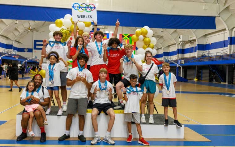 Group of children all wearing matching t-shirts and medals