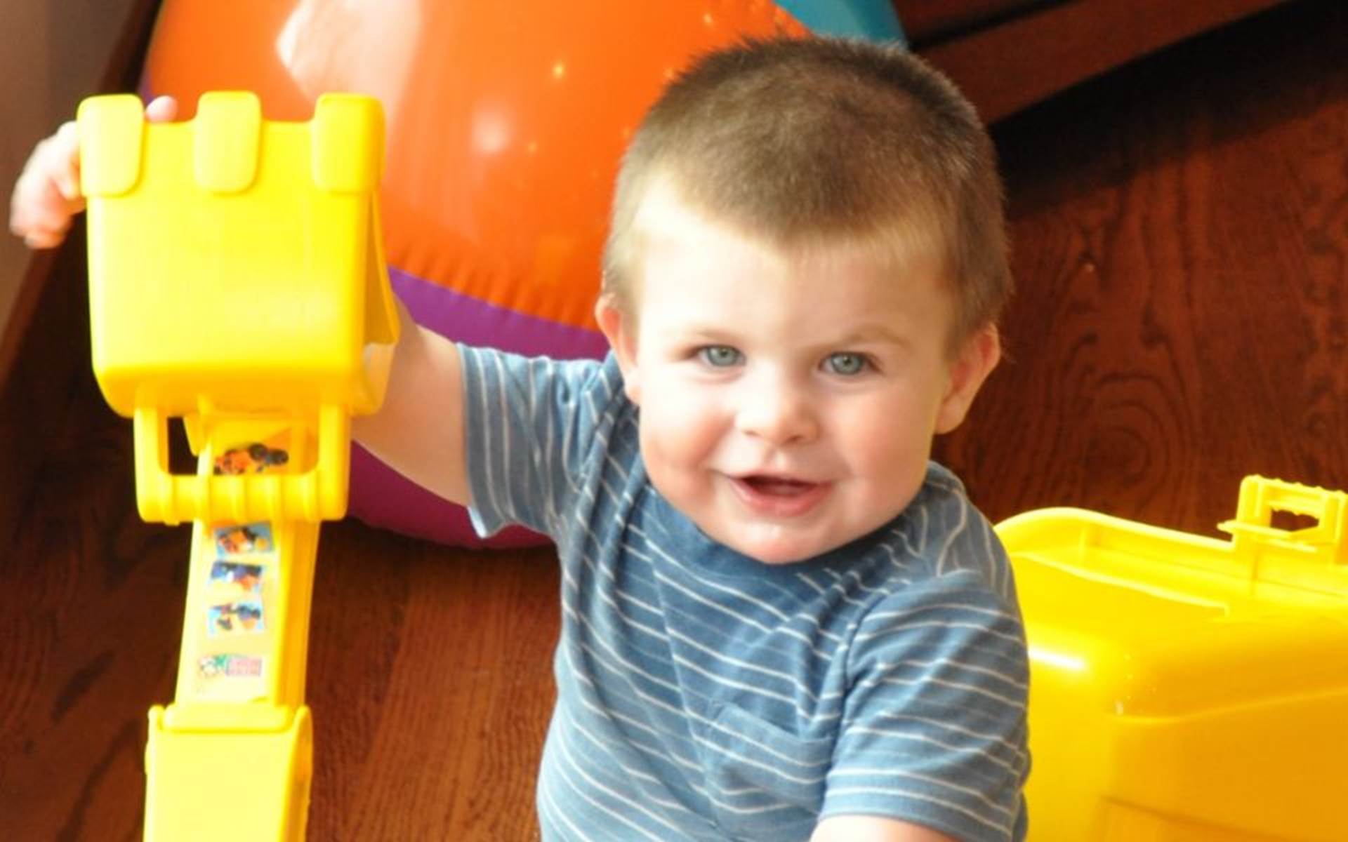 Little Boy Playing With Yellow Truck Toy