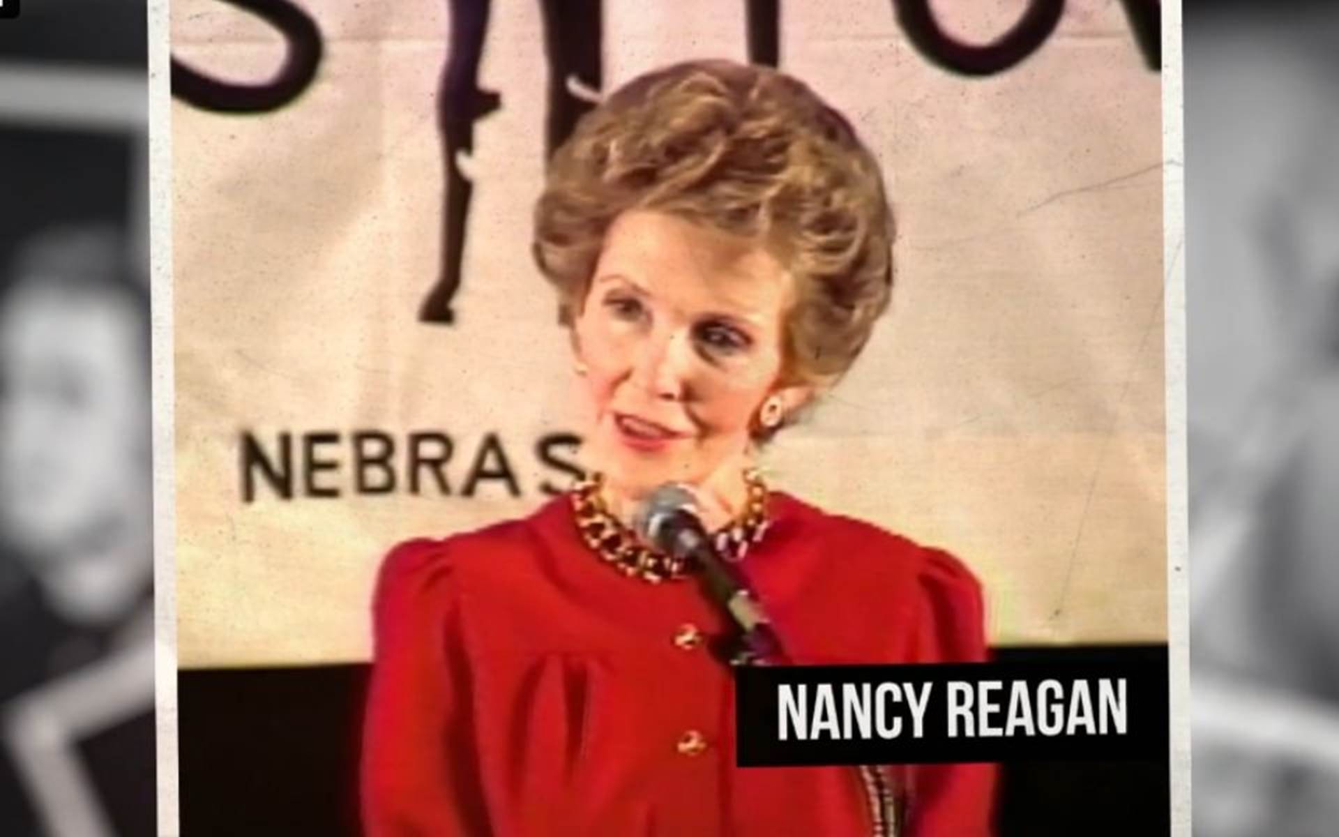 Women with a red dress talking into a microphone 