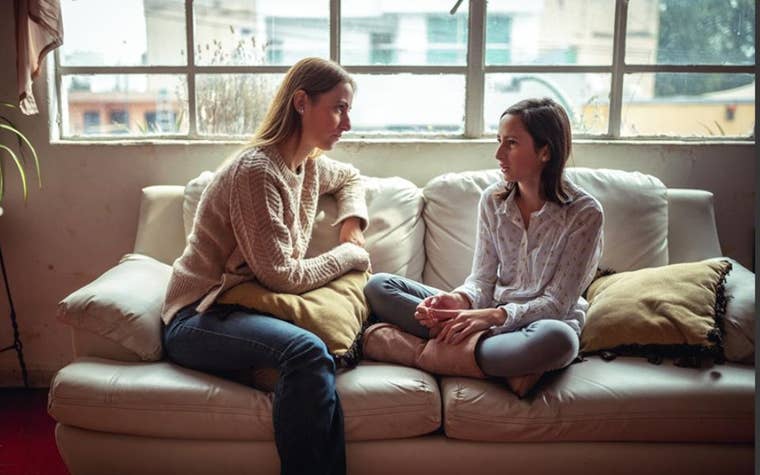 Mom talking with her daughter on the couch 