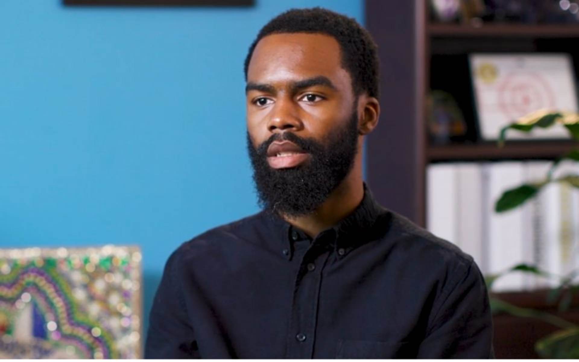 Young man with a beard talking in an office space