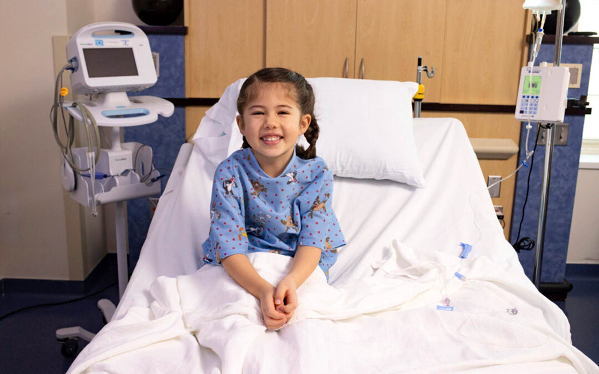 Little girl smiling in Boys Town Hospital bed