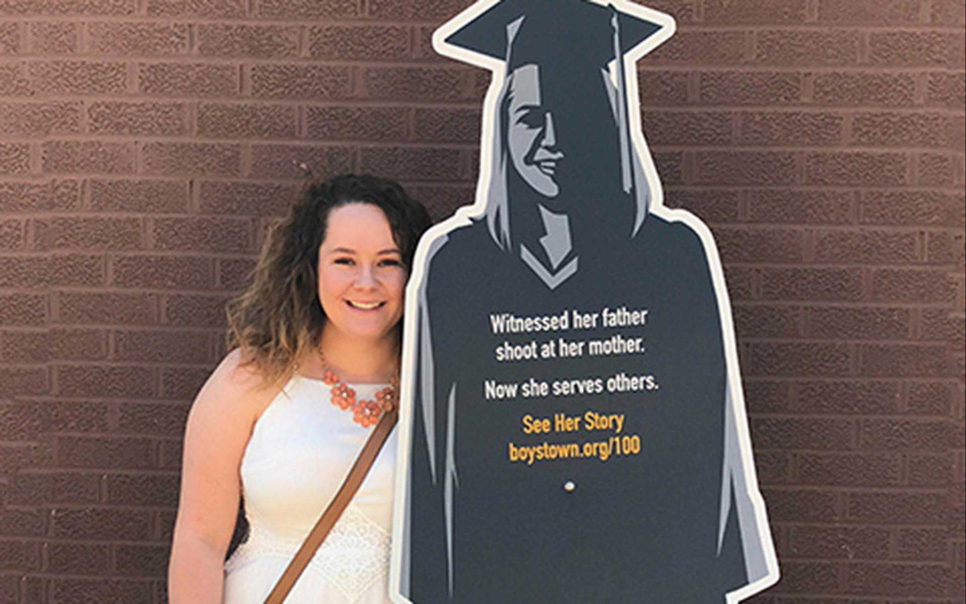 Boys Town student next to her cardboard cutout of 100 years