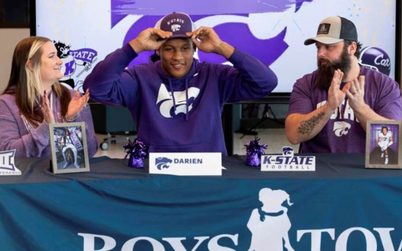 young man accepting a school scholarship to play football