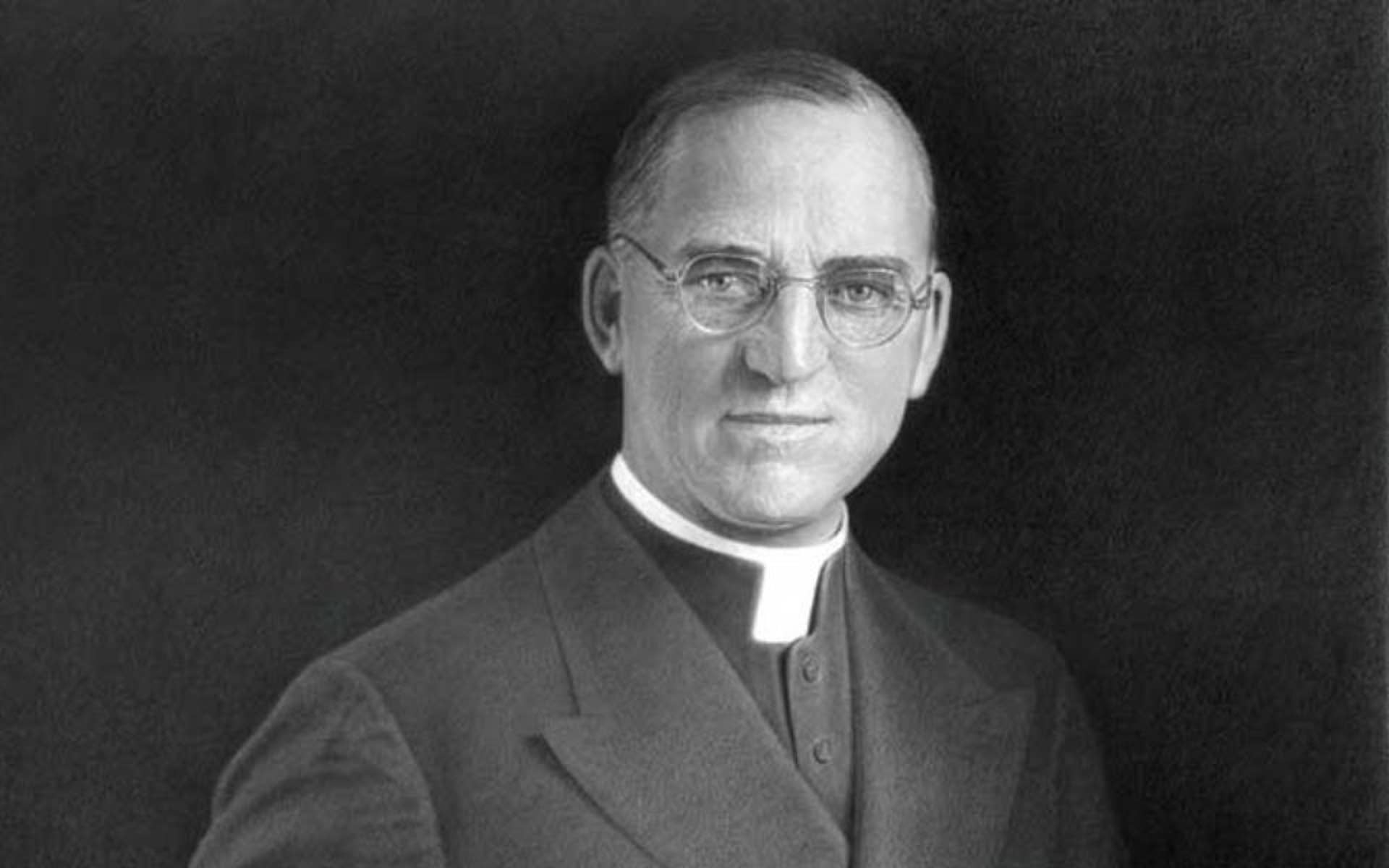 black and white photo of a man in priest clothes