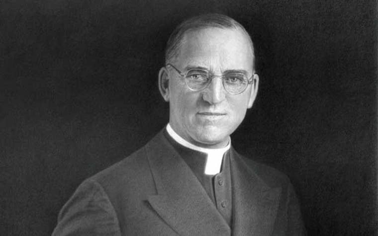 black and white photo of a man in priest clothes