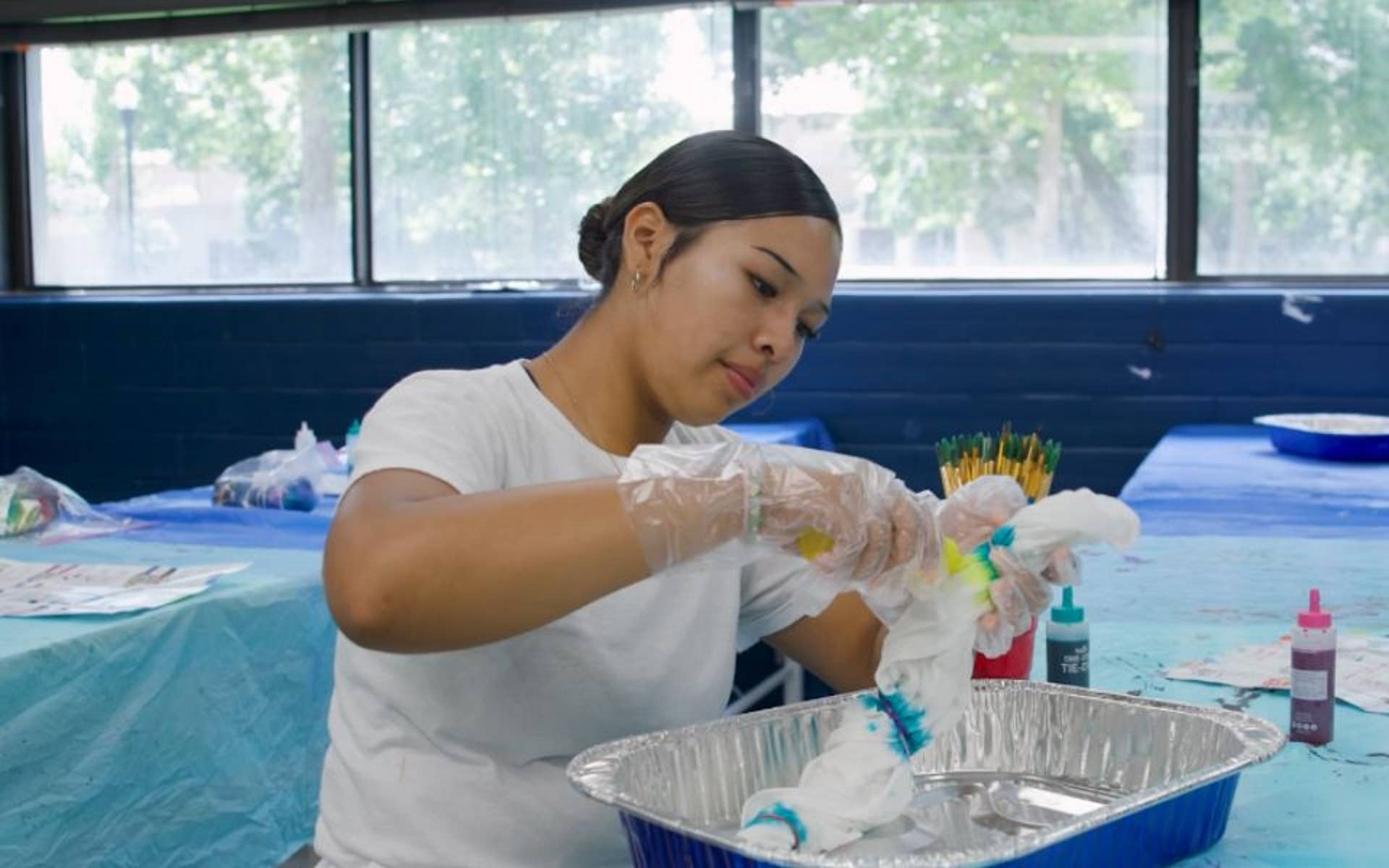 girl working on crafts and tie dying a shirt