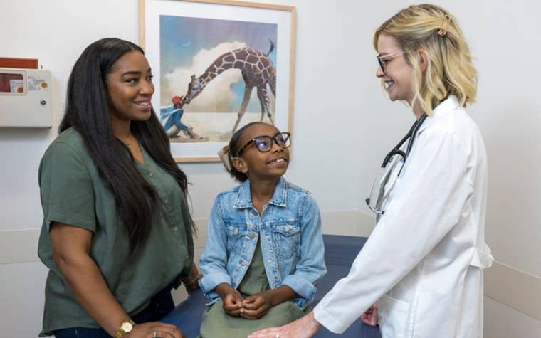 Mom and daughter in a doctor's office speaking with the doctor