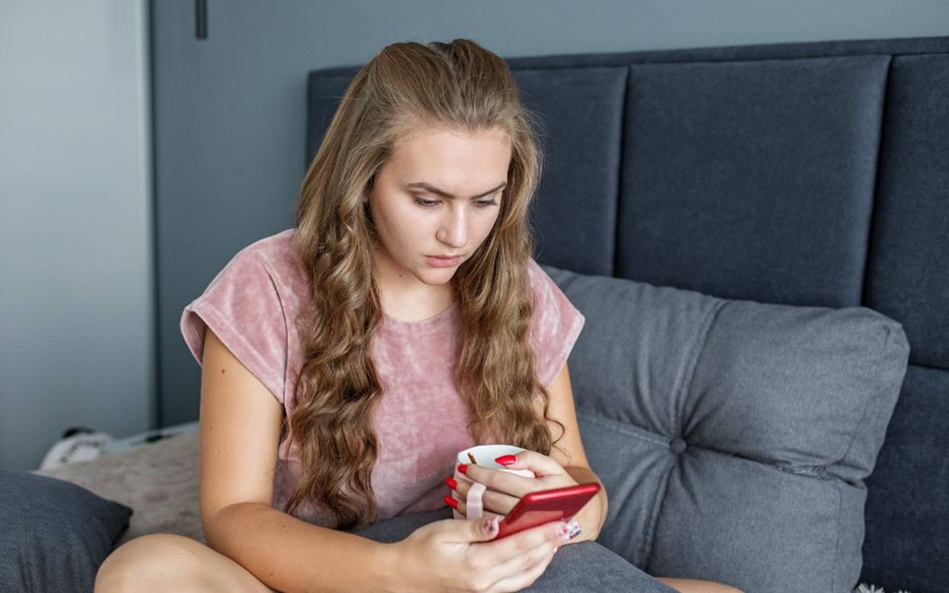 young girl looking upset reading off her phone