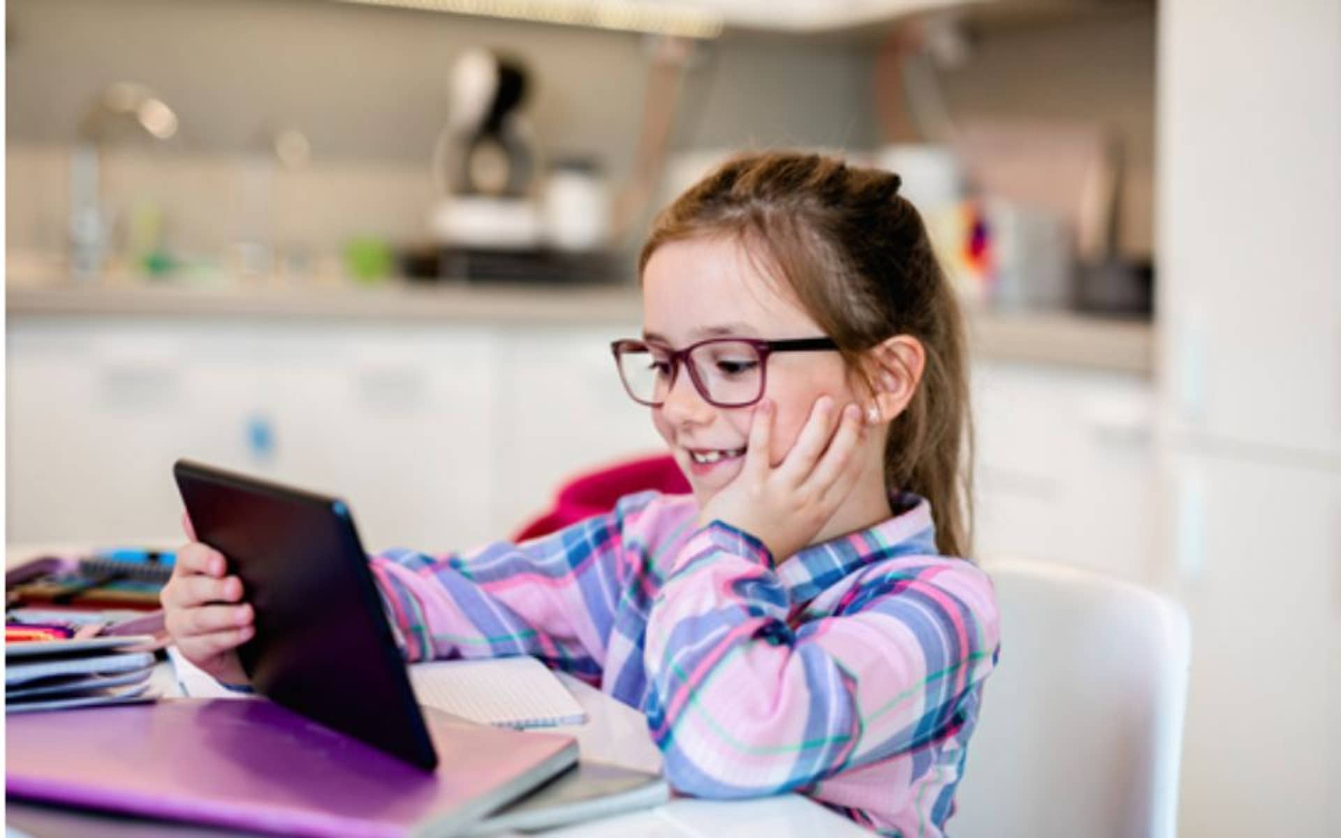 young girl with glasses watching her tablet