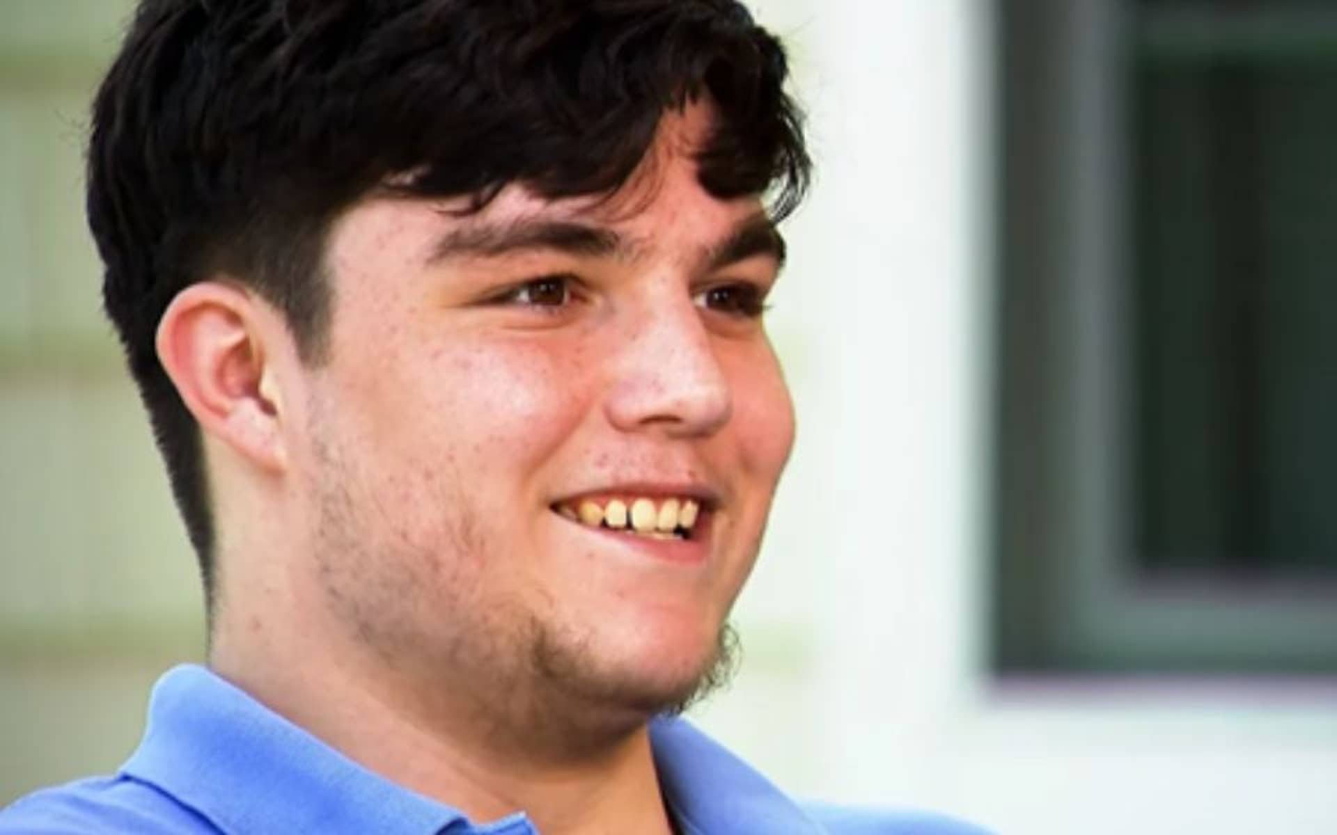 Young man with dark brown hair smiling