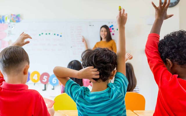 Children in class raising their hands
