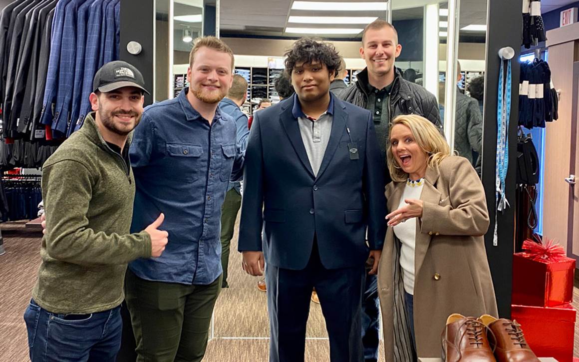 Group of employees from Bridgepoint Investment with Boys Town youth trying on new suit