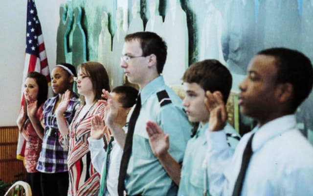 Children in class raising their hands