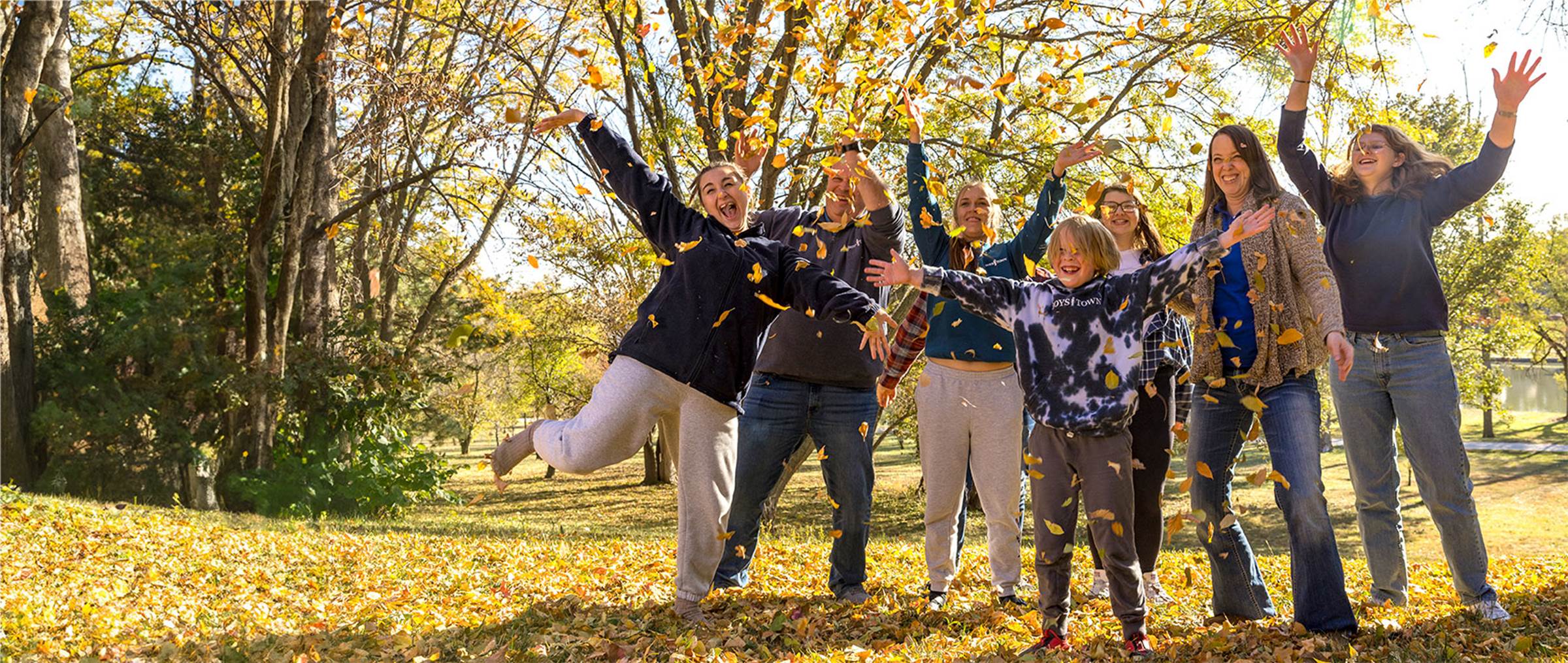 Family playing in the fall leaves