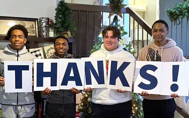 Boys Town kids holding up Thanks Sign
