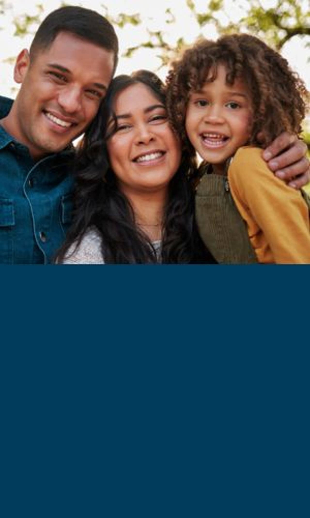 Family of three outside smiling
